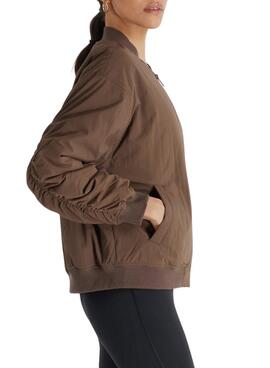 Veste Bomber New Balance Graphic Woven marron pour femme.